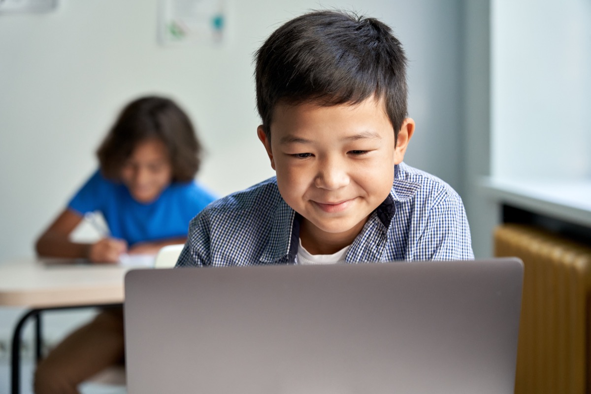 A pupil concentrating while working on a laptop