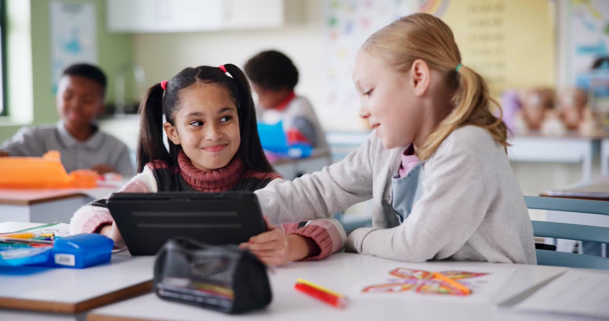 Two pupils looking at a tablet together in class