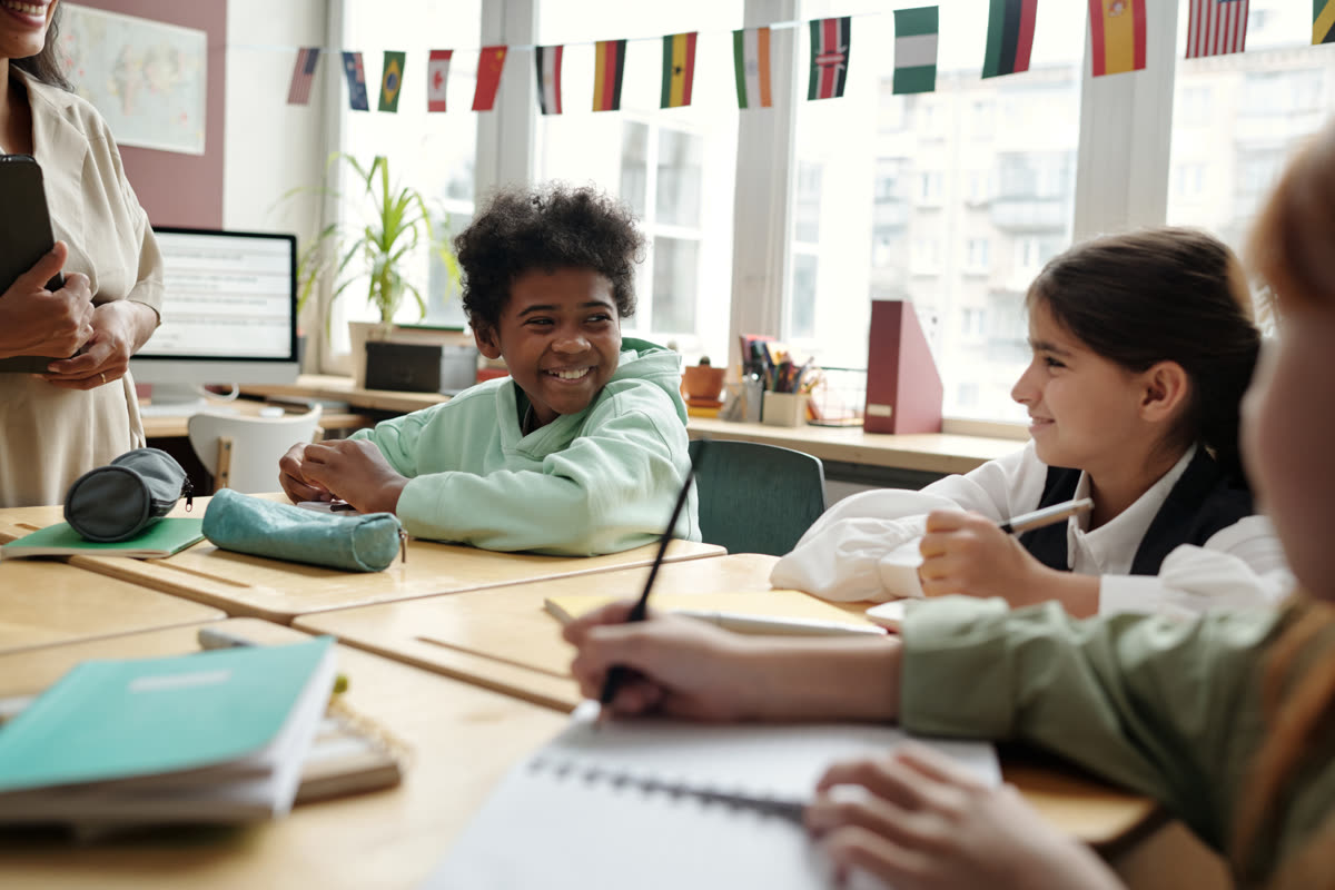 Classmates talking together at their desks